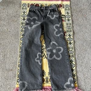 i’m selling a pair of gray denim jeans with white flowers.